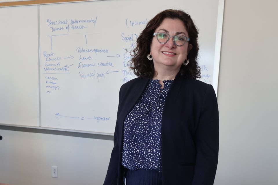 Daniell Pelfrey Duryea poses in the classroom in front of a white board.