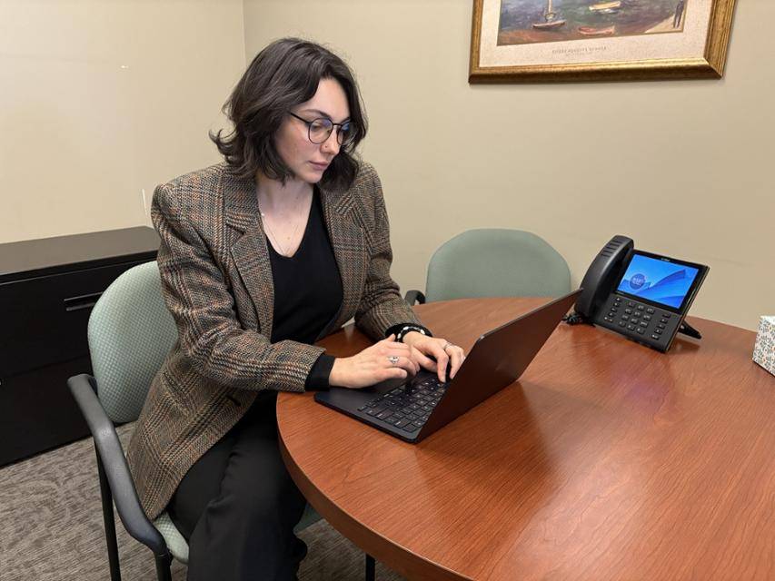 Clinic student Shannon Besch sits at a table in the legal clinics working on her laptop