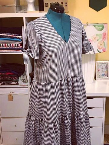 Pictured is a dress that doctor Salle sewed. It is blue and has a checkered pattern Pictured is a dress that doctor Salle sewed. It is blue and has a checkered pattern