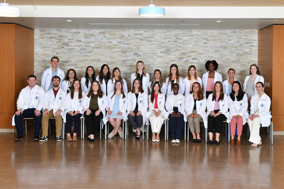 Resident Class A group of about 20 residents pose for a photo outdoors.