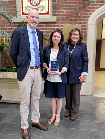 Three people stand inside the Chaifetz School of Business.